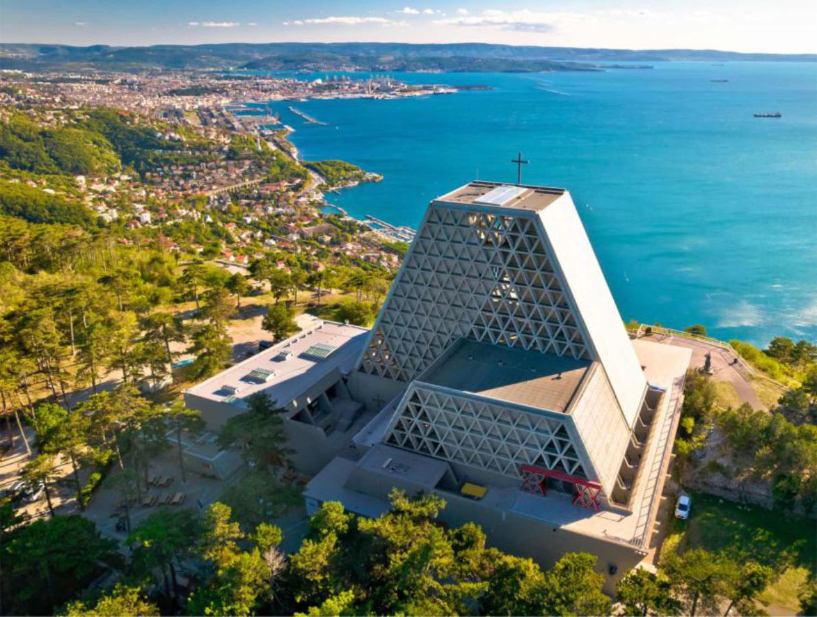 Betongebäude mit Bäumen drumherum, Meeresbucht mit Wohngebiet