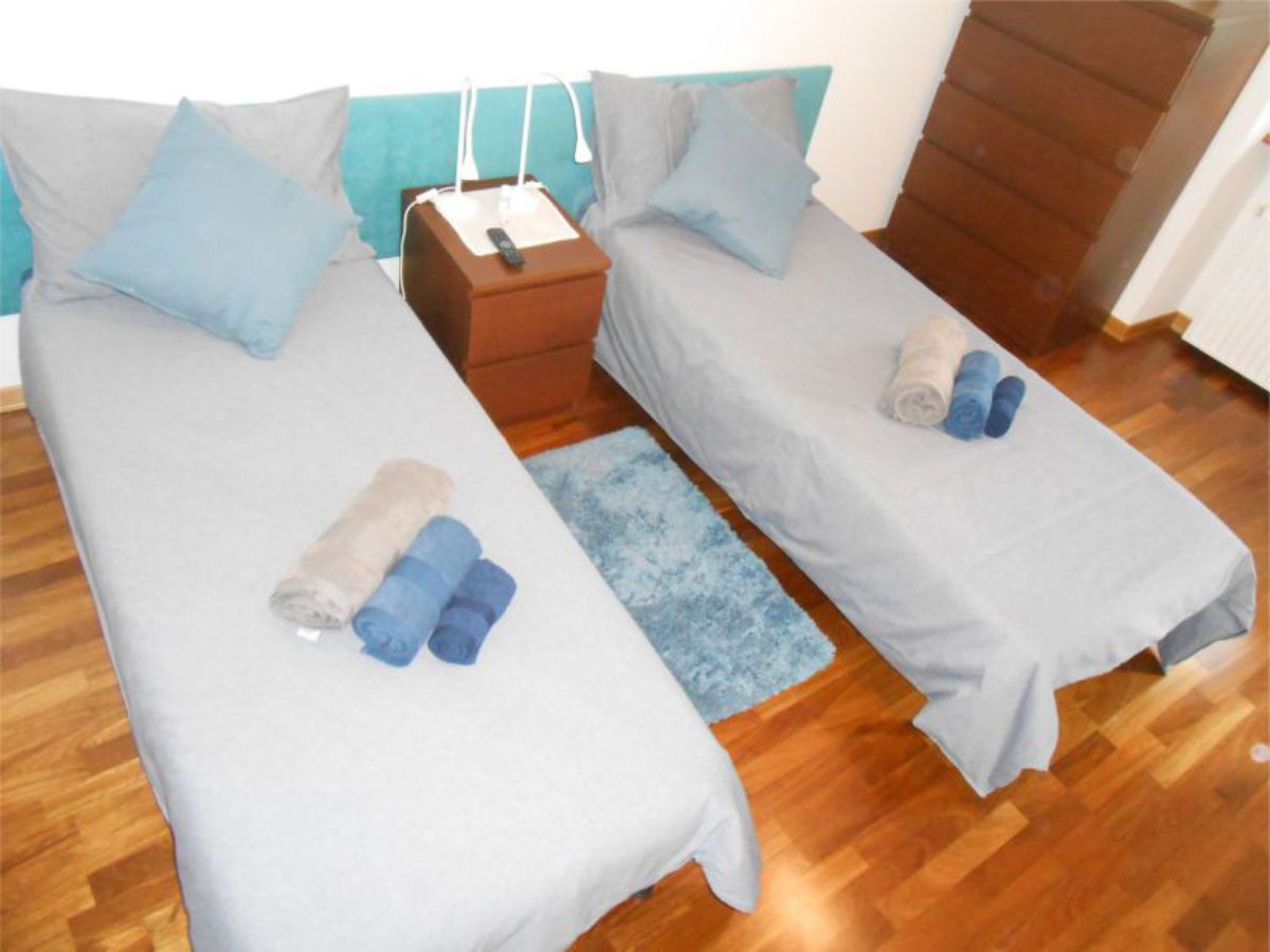single bed, table lamps, wardrobe and window in the background
